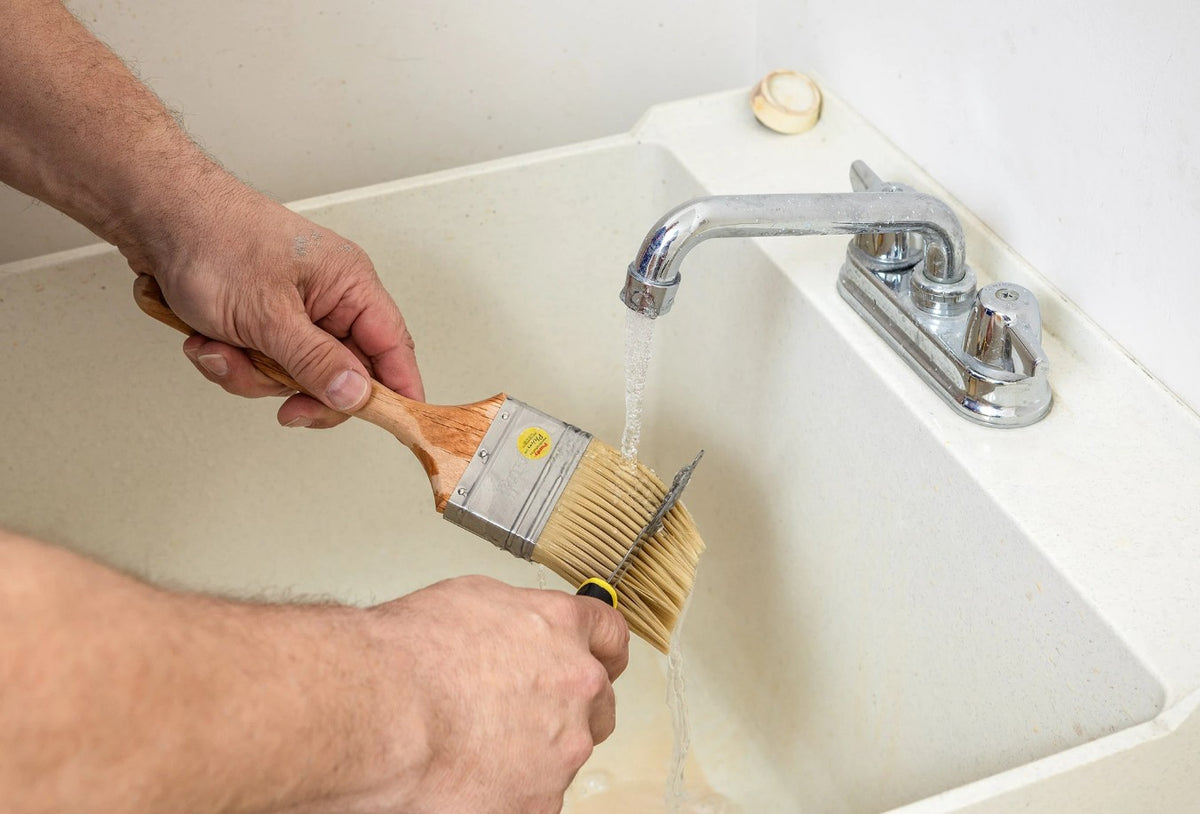 Man cleaning the Purdy Chinex Elite Glide paint brush with a purdy brush comb.