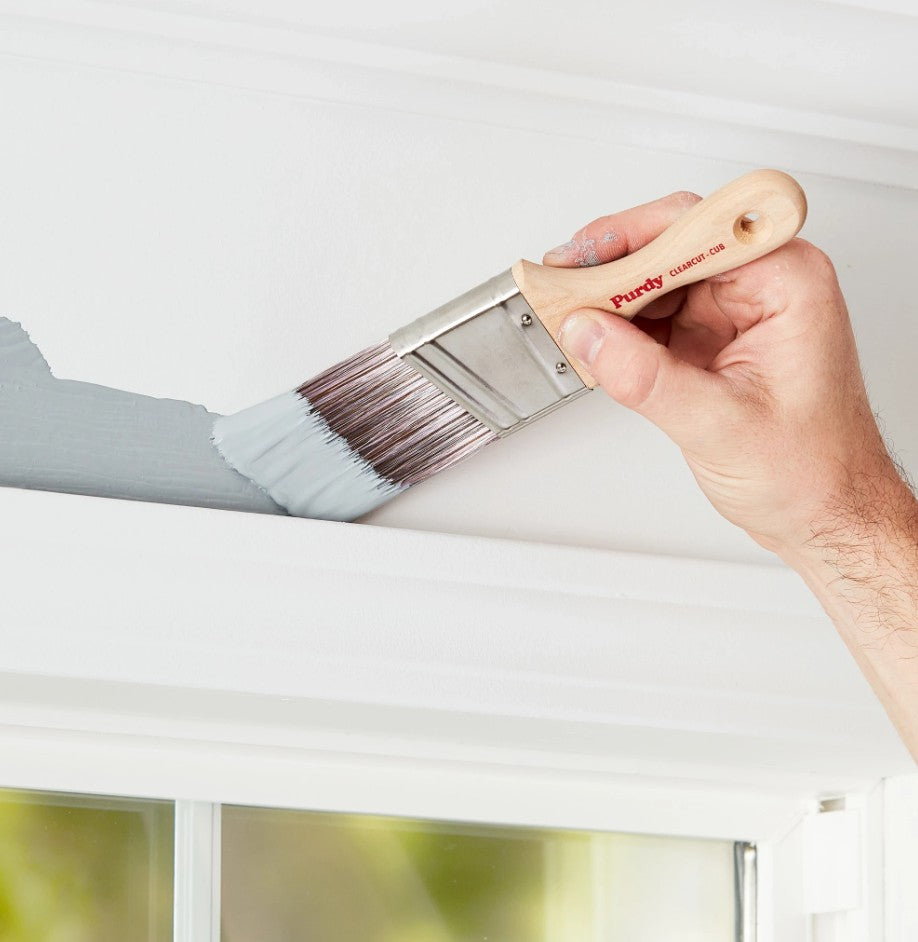 Man painting above a window with the Purdy Clearcut Cub paint brush.