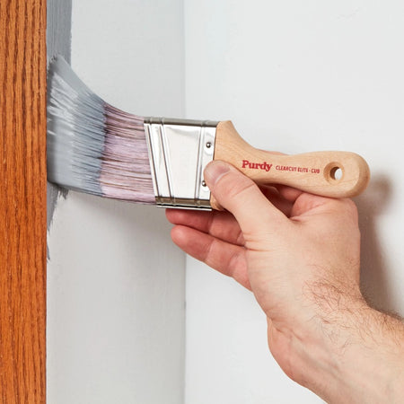 Man painting around wall trim with the Purdy Clearcut Elite Cub paint brush.