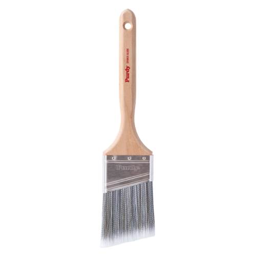 A single paint brush with a light natural wood handle, silver metal bristles, and a clear plastic guard, shown against a plain white background. The brand name 'Purdy' is printed in red on the handle.