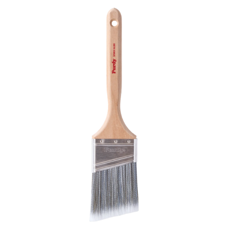 A single paint brush with a light natural wood handle, silver metal bristles, and a clear plastic guard, shown against a plain white background. The brand name 'Purdy' is printed in red on the handle.