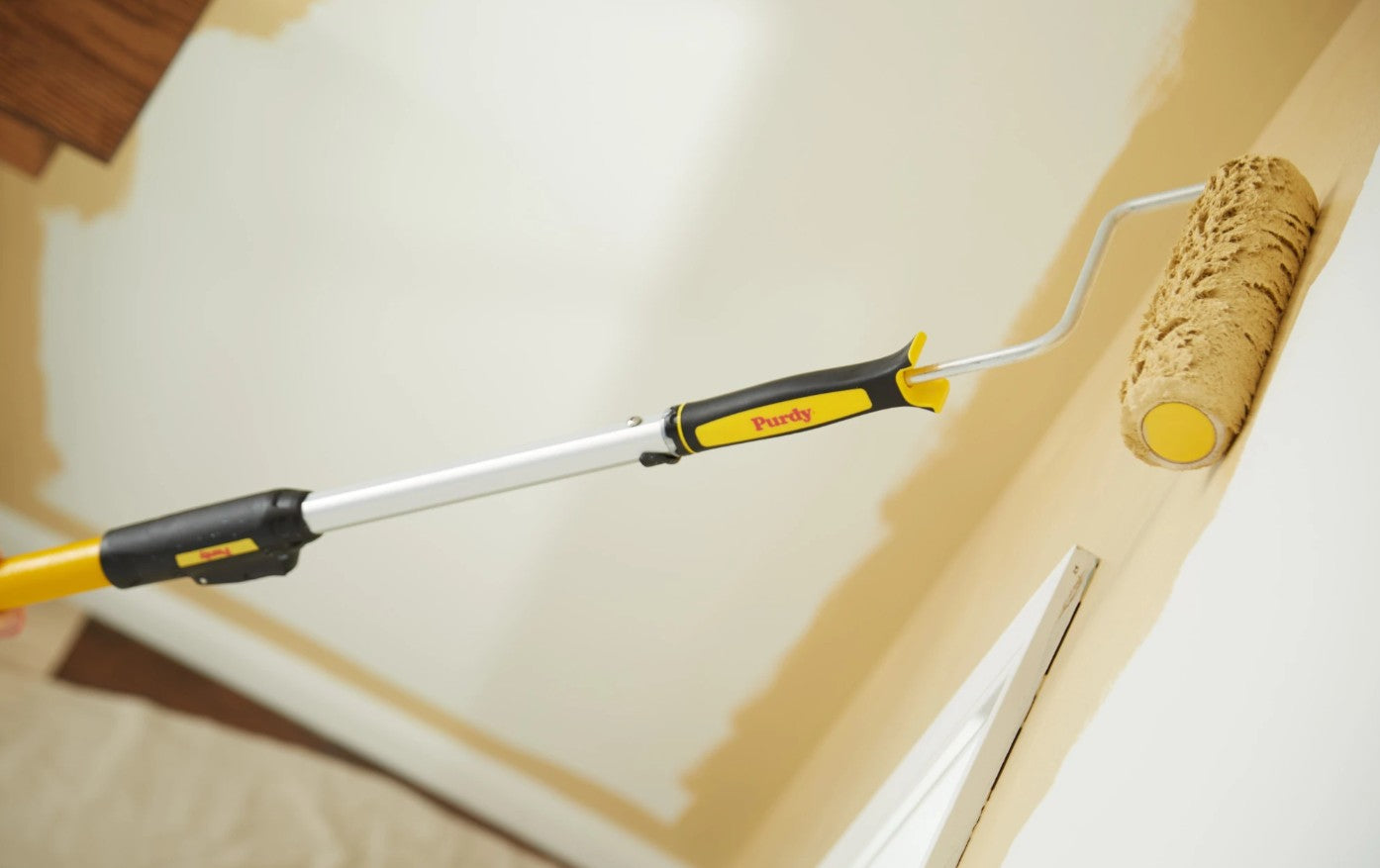 Paint being applied to a wall with the Purdy Ultra Finish Roller cover on a purdy extension pole.