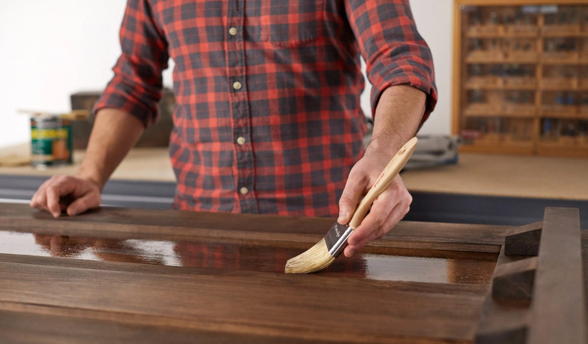 Main painting a table with Purdy White Sprig paint brush.