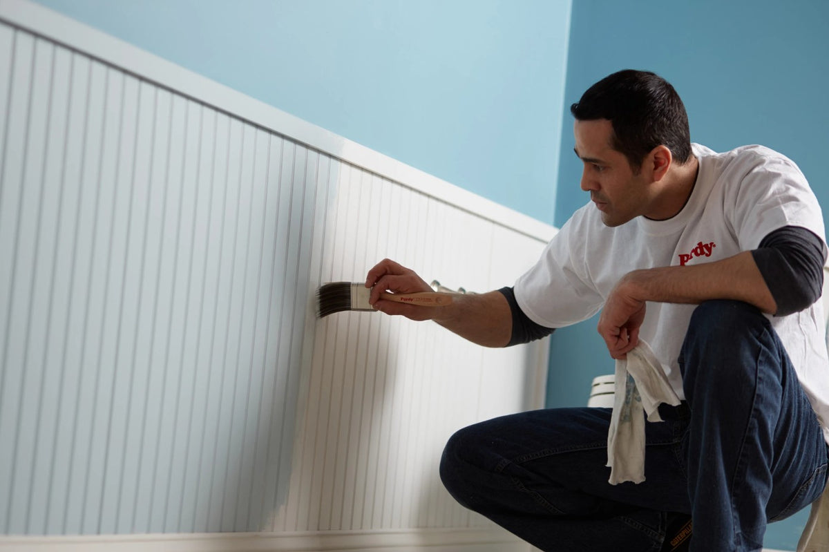 Man painting a wall with the Purdy XL Blue Heron paint brush.