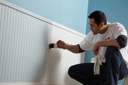 Man painting a wall with the Purdy XL Blue Heron paint brush.