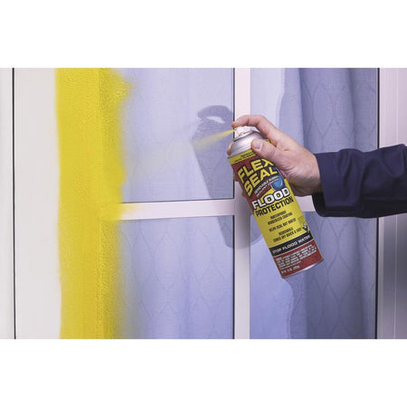FLEX SEAL Flood Protection Waterproof Rubberized Coating Spray Sealant 10 Oz RFSYELR16 being applied to the exterior of a door window.
