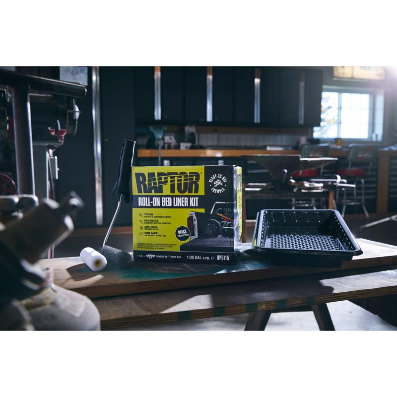 Raptor roll-on bed liner kit packaging on a table with a blurred indoor background