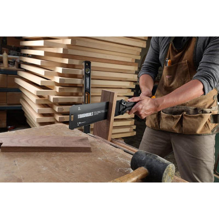 ToughBuilt Folding Pull Saw being used to saw a piece of wood.