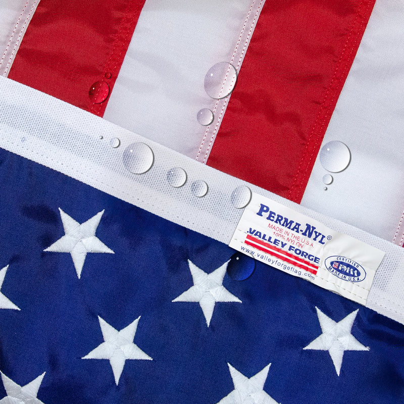 Close-up of a flag with a Perma-Nyl label showing water droplets not penetrating the flag.