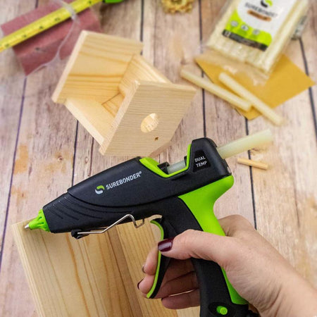 Surebonder glue gun being used on wooden blocks with SureBonder WS-12 glue sticks in the background