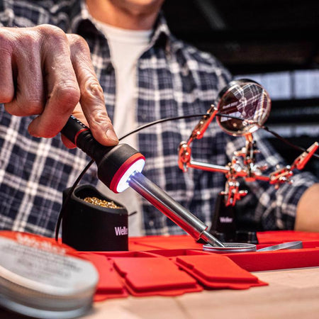 Weller Corded Soldering Iron Kit shown being used to solder small pieces on a mirrored object.